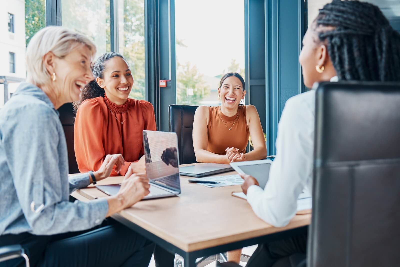Laughing, planning business and women in a meeting for strategy, teamwork and a workforce team. Happy, office and diversity with people at work for a corporate collaboration and coworking together.